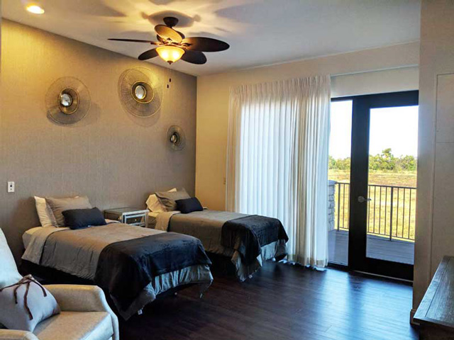 lovely cream colored bedroom with 2 beds and large patio access