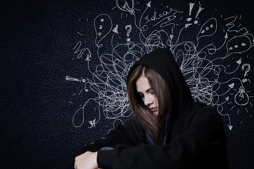 young girl in black hooded sweatshirt with chalk drawings above head depicting anxiety - anxiety disorders