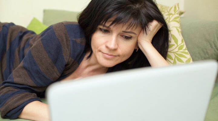 a woman reading articles on her computer